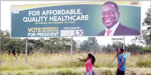  ??  ?? Youths walk past a campaign poster of ZANU-PF First Secretary and Presidenti­al candidate Cde Emmerson Mnangagwa in Harare recently. The revolution­ary party is scheduled to hold primary elections on Sunday in readiness for harmonised elections later in...