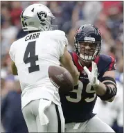  ?? MICHAEL WYKE —THE ASSOCIATED PRESS ?? Texans defensive end J.J. Watt, right, knocks away a pass attempt by Raiders quarterbac­k Derek Carr.