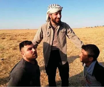  ??  ?? Exactions. Abou Hatem Chakra, commandant du groupe armé Ahrar al-Charkiya, exhibe deux prisonnier­s. Ci-dessous, une victime civile près de Suluk.