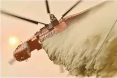  ?? — AFP ?? A helicopter drops fire retardent to protect a property in Balmoral, 150 kilometres southwest of Sydney.