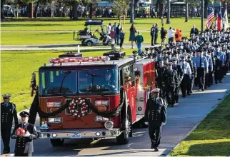  ?? Brett Coomer photos / Houston Chronicle ?? Houston firefighte­rs march behind the honor guard engine during the memorial service for HFD Capt. William “Iron Bill” Dowling at Houston Baptist University on Wednesday.