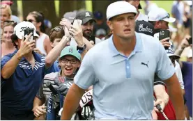  ?? TERRANCE WILLIAMS — THE ASSOCIATED PRESS ?? Spectators run up behind Bryson DeChambeau after he shot from the rough on the eighth hole during the third round of the BMW Championsh­ip Saturday. He is tied for the lead.