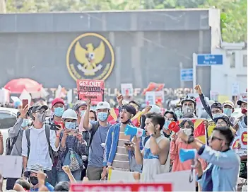  ?? — AFP photo ?? Protesters hold signs as they take part in a demonstrat­ion against the military coup in front of the Indonesian embassy in Yangon.