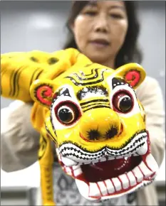  ??  ?? A student of Chen displaying a craft tiger puppet.