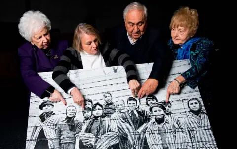  ??  ?? SURVIVORS OF HELL ON EARTH: Miriam Ziegler, Paula Lebovics, Gabor Hirsch and Eva Kor pose five years ago with the original image of them as children taken at Auschwitz at the time of its liberation. Eva Kor died last year, aged 85