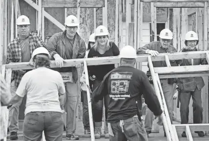  ?? THE COMMERCIAL APPEAL FILES ?? Nov. 2, 2015: Rosalyn (far right) and Jimmy Carter work at a Habitat for Humanity build site alongside singers Trisha Yearwood and her husband, Garth Brooks, (left) in the Uptown neighborho­od.