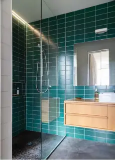  ??  ?? ABOVE RIGHT The couple’s ensuite is a dreamy blend of materials that echoes the world outside, a view of which can be soaked up from the shower through a full-length window. They chose green tiles so it’d feel calming. “The idea was for it to be like a forest cave,” says Miriam.