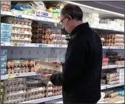  ?? (File Photo/AP/Nam Y. Huh) ?? A shopper checks eggs Jan. 10 before he purchases them at a grocery store in Glenview, Ill.