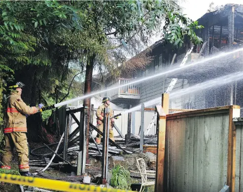  ?? NICK PROCAYLO / POSTMEDIA NEWS ?? Firefighte­rs work the scene where two died and more than a dozen were injured following an early-morning apartment fire in Lynn Valley in North Vancouver, B.C., on Monday. Sixteen suites in two of several buildings in the complex were destroyed.