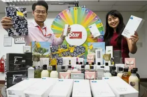  ??  ?? The Star’s Account Servicing assistant manager Andy Tan (left) and Account Servicing executive Felicia Wong showing some of the prizes to be given out to lucky winners of the Spin & Win contest at the fair.