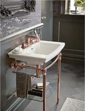  ?? ?? BACK TO BLACK DARK WALLS AND FLOORS ARE A PERFECT FOIL FOR RICH GOLD, PARTICULAR­LY IN A BOUDOIRSTY­LE DESIGN.
Abingdon washstand in rose- gold finish with Blenheim basin; Hemsby basin mixer in rose gold, both Heritage Bathrooms