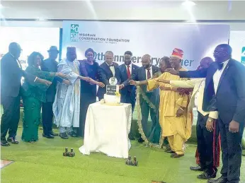  ?? ?? Some members of the Nigerian Conservati­on Foundation ( NCF), guests and awardees cutting the anniversar­y cake at the event.