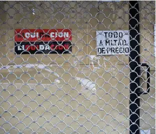  ?? ?? Un comercio con el cierre echado como consecuenc­ia de la crisis.