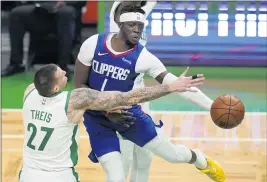  ?? ELISE AMENDOLA – THE ASSOCIATED PRESS ?? Clippers guard Reggie Jackson, right, passes the ball as he’s defended by Celtics center Daniel Theis. Jackson finished the game with 25 points and seven assists.