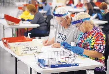  ?? ADOLPHE PIERRE-LOUIS/JOURNAL ?? Chuck Lorenzen and Theresa Bennett process absentee ballots for the New Mexico primary contests on Tuesday at the Bernalillo County Bureau of Elections Voting Machine Warehouse, 2400 Broadway SE.