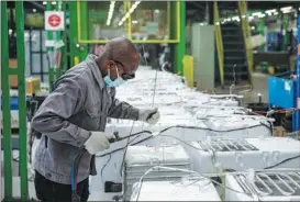  ?? PHOTOS BY XINHUA ?? From left: South African President Cyril Ramaphosa answers questions about the BRICS partnershi­p in Cape Town, South Africa, on June 10; Work is carried out on the assembly line for Hisense refrigerat­ors in Cape Town on June 1.