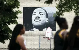  ?? Tribune News Service ?? ■ A parade passes by a banner depicting Martin Juneteenth Day Festival in Milwaukee, Wisconsin.
Luther King
Jr.
during
the 2019