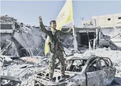  ??  ?? 0 A member of SDF raises the flag in Al-naim square