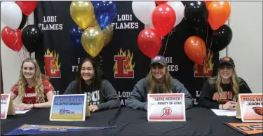  ?? NEWS-SENTINEL PHOTOS BY MIKE BUSH ?? Above: Taking part in Signing Day at Lodi High on Nov. 14 are (left to right) Rachel Sutter, soccer, University of Louisiana; Madison Liu, diving, Cal Baptist University; Madeline Woznick, swimming, University of Utah and Paige Sefried, track and field, Oregon State. Below: Bella Minatre signs with Jamestown University inside Warrior Gym on Wednesday.