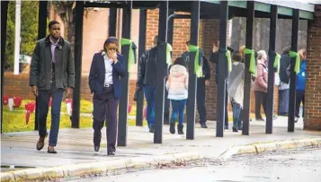  ?? JOHN C. CLARK AP ?? Newport News Mayor Phillip Jones and school board Chair Lisa Surles-Law leave Richneck Elementary School to speak to news media on Monday in Newport News, Va. The school reopened with more security.