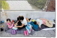  ?? AP/ERIC GAY ?? People from Cuba and Guatemala seeking asylum in the United States wait Friday on the Matamoros Internatio­nal Bridge over the Rio Grande in Matamoros, Mexico.