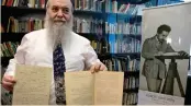  ??  ?? Hebrew University’s Roni Gross in Jerusalem on Thursday holds the original historical documents related to Albert Einstein’s prediction of the existence of gravitatio­nal waves.