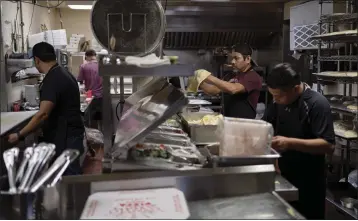  ?? DANIELLE VILLASANA — THE NEW YORK TIMES ?? A pizza is prepared in the kitchen of Star Pizza's original location in Houston on Jan. 23. Star Pizza lost power in its 50-year-old location in Houston during a winter storm in 2021.