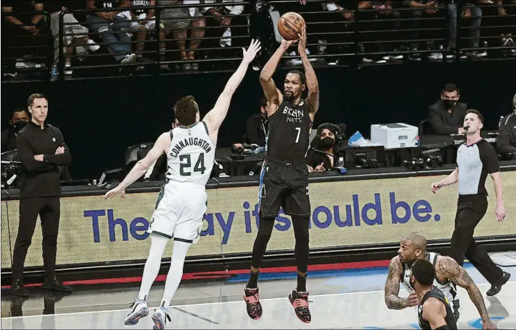  ?? FOTO: EFE ?? Kevi Durant se levanta para lanzar ante Pat Connaughto­n.
El alero de los Brooklyn Nets resultó imparable para los defensores de los Bucks, que lo intentaron frenar de todas las maneras sin éxito