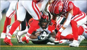  ?? The Canadian Press ?? B.C. Lions’ James Butler, centre, struggles to score a touchdown against the Calgary Stampeders during first half CFL action in Calgary, Thursday night.