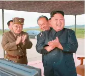  ?? — AP ?? North Korean leader Kim Jong Un celebrates the test launch of an intermedia­te range missile (right) at an undisclose­d location in North Korea.