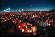  ?? The Associated Press ?? ■ People attend a candleligh­t vigil for the victims of the shooting at Marjory Stoneman Douglas High School in Parkland, Fla., on Feb. 15, 2018.