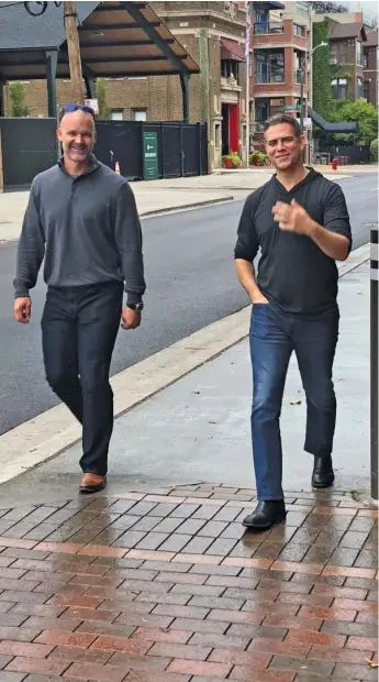  ?? GORDON WITTENMYER/SUN-TIMES ?? Former Cubs catcher David Ross and team president Theo Epstein share a laugh outside of Wrigley Field on Thursday. Ross was the fourth candidate to interview for the Cubs’ managerial job.