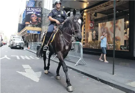  ??  ?? Robert D’Aamodio, a New York City Police Department mounted unit officer, rides McQuade II through New York’s Theater District, before the horse is reshod at the department's farriers’ mobile workshop in Times Square. The NYPD has two such mobile...