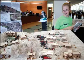  ?? NWA Democrat-Gazette/DAVID GOTTSCHALK ?? Joy Gilbert of Fayettevil­le looks Wednesday at the University of Arkansas’ Community Design Center’s livability plan for Willow Heights, a public housing apartment complex near downtown, on display at the Fayettevil­le Public Library. Models of the center’s plan includes facade improvemen­t and landscapin­g.