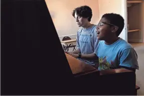  ?? PHOTOS BY MARK ZALESKI/AP ?? Grayson Hart and cast member Evan Roberts, 11, rehearse a song at the Ned R. Mcwherter West Tennessee Cultural Arts Center in Jackson. Hart, who directs a youth theater program, was accepted into every college he applied to, but turned them down.