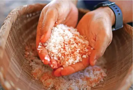  ?? AP PHOTO/JESSIE WARDARSKI ?? Malia Nobrega-Olivera, a Native Hawaiian salt maker, holds Hawaiian salt, or “paakai,” July 10 in Hanapepe, Hawaii.