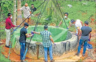  ?? PTI PHOTO ?? Animal husbandry department and forest officials use a net to collect bats from the well of a house after the outbreak of Nipah virus in Kerala’s Kozhikode district on Monday.