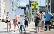  ?? RICARDO RAMIREZ BUXEDA/ORLANDO SENTINEL ?? A group protests delays in processing of unemployme­nt benefits at Lake Eola Park in downtown Orlando last week.