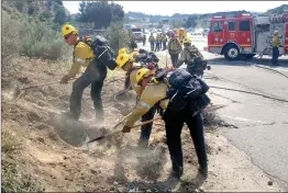  ?? ?? (Bottom) Hand crew members clear brush that could possibly be used to fuel more as the Los Angeles County Fire Department handles a quarter-acre brush fire on Highway 14.