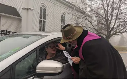  ?? RENEE BORCAS — THE NEWS-HERALD ?? Pastor Ian Lynch distribute­s ashes to a community member during an Ash Wednesday drive through at Old South United Church of Christ in Kirtland.