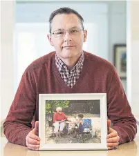  ?? ANDREW FRANCIS WALLACE TORONTO STAR ?? Craig Lindsay, with a photo of his mother was her caregiver while she was dying of cancer six years ago. Ontario’s health system is placing undue pressure on caregivers, a report says.