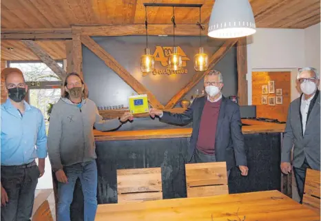  ?? FOTO: LEADER MITTLERE ALB ?? Hannes Runknagel und Alexander Reuß (v. l.) bekommen die LEADER-Plakette als Zeichen der erfolgreic­hen Projektums­etzung von Landrat Heinz Eininger und Werner Huber vom LEADER-Beirat überreicht.