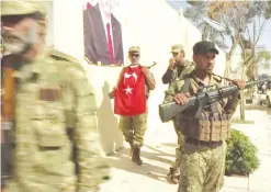  ??  ?? DABIQ, Syria: Turkish-backed Syrian opposition forces, one carrying a Turkish flag, patrol in this symbolical­ly significan­t town yesterday. — AP