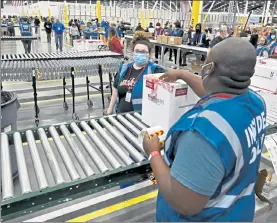  ?? AP ?? The first box containing the Johnson & Johnson COVID-19 vaccine heads down the conveyor line to an awaiting truck at the McKesson facility in Shepherdsv­ille, Ky., on Monday.