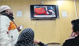  ?? AP FILE ?? ■ People watch a news report on TV about Mullah Fazlullah at a coffee shop in Islamabad.
