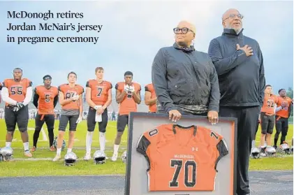  ?? PHOTOS BY KARL MERTON FERRON/BALTIMORE SUN ?? Tonya Wilson and Martin McNair stand with the McDonogh football team during the national anthem ceremony. McDonogh retired No. 70, worn by Jordan McNair, who died June 13 after suffering heatstroke during a Maryland conditioni­ng test two weeks earlier.