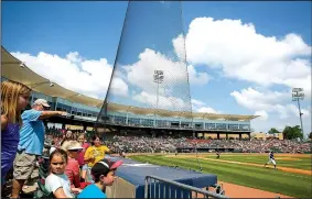  ?? NWA Democrat-Gazette/JASON IVESTER ?? Fans watch from behind the netting, which was extended to the end of each dugout before this season, Tuesday during the Naturals’ game against the Arkansas Travelers at Arvest Ballpark in Springdale. The added netting was to help ensure fan safety at...