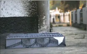  ?? AP PHOTO/MARCO UGARTE ?? An empty coffin that once held the body of a COVID-19 victim sits outside the crematoriu­m at the San Nicolas Tolentino Pantheon as workers cremate bodies in the Iztapalapa area of Mexico City, early Friday.