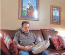  ?? DOUG HOKE/THE OKLAHOMAN ?? Scott George sits under a portrait he painted of one of his mentors, the late Morris Lookout, at his home in Del City on Feb. 22.