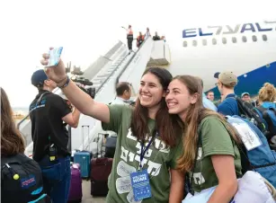  ?? (Shahar Azran) ?? TWO NEW IMMIGRANTS snap a selfie yesterday upon landing at Ben-Gurion Airport.